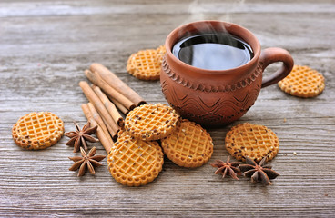A cup of hot tea with cookies on a rustic wooden background