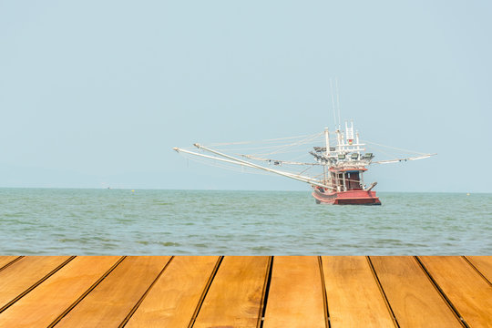 Wooden table with Fishing boat in sea, fishing for squid.
