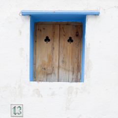 Ventana de madera con marco azul sobre pared blanca