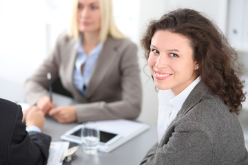 A group of business people at a meeting on the background of office. Focus on a beautiful brunette