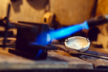Jeweler using tourch to heat welding tools
