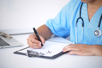 Portrait of unknown male surgeon doctor holding his stethoscope and filling up medical prescription