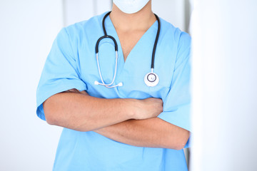 Portrait of unknown male surgeon doctor standing near the wall  in hospital office