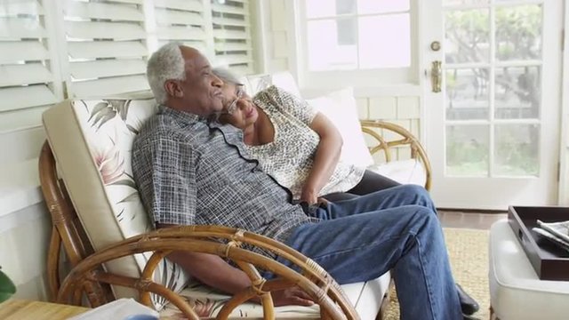 Senior black couple relaxing on couch together