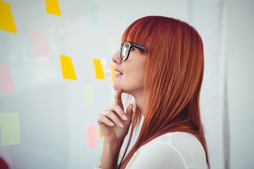 Attractive hipster woman looking at sticky notes