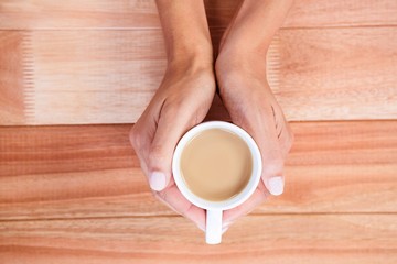 Womans hands holding cup of coffee