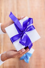 Woman presenting gift with purple ribbon