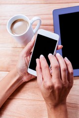Businesswoman using her smartphone on desk