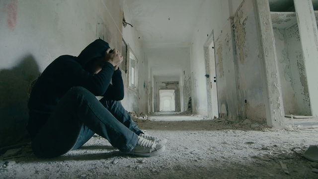 Troubled young man in wrecked abandoned building 