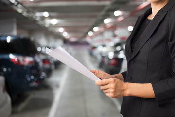 Businesswoman in Underground parking with cars.