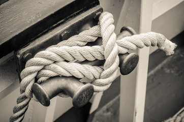 Rope tied to bollard sailboat, sepia