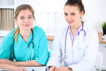 Fototapeta premium Female doctor and young surgeon intern in hospital