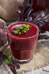 a glass of fresh beetroot juice on old rustic table