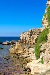 Fototapeta na wymiar Mediterranean sea with green rocky beach.