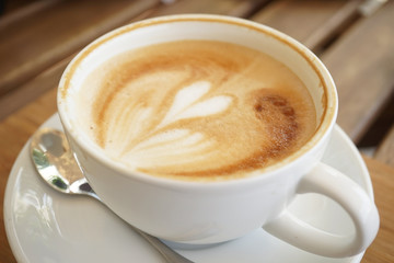 a cup of coffee on the wooden table
