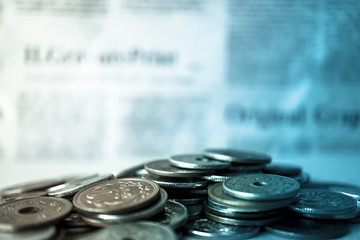 pile coins on blur newspaper background
