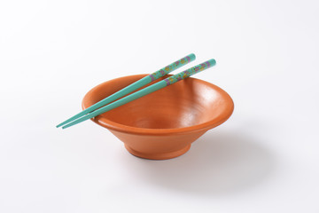 Blue chopsticks on a bowl