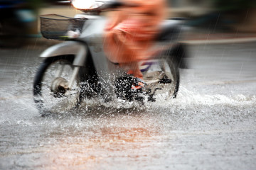 Splash by a bike through flood water after hard rain,blurry move