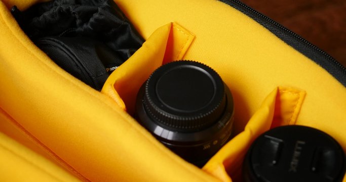 close up of male hands packing photographic equipment into photo bag