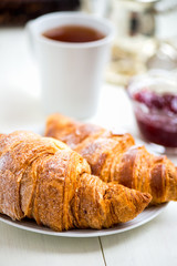 Fresh Croissants with Icing, Cup of Tea and Strawberry Jam