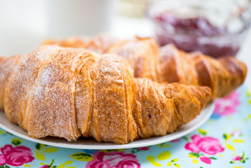 Fresh Croissants with Icing, Cup of Tea and Strawberry Jam