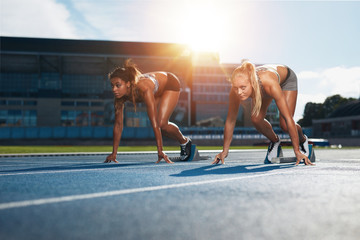 Determined female athletes ready to start a race - obrazy, fototapety, plakaty