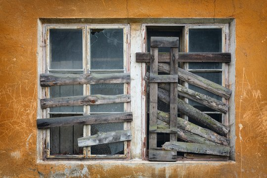 two old boarded-up window on the wall