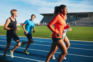Obraz premium Fit men and women running on a race track