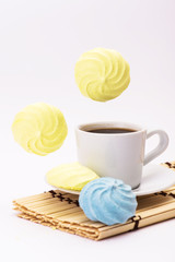 flying meringues and cup of coffee on a white background