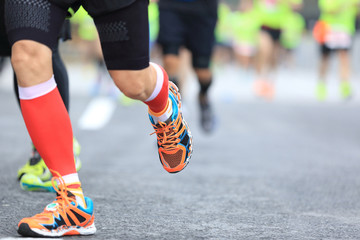 Fototapeta na wymiar marathon runners legs running on city road