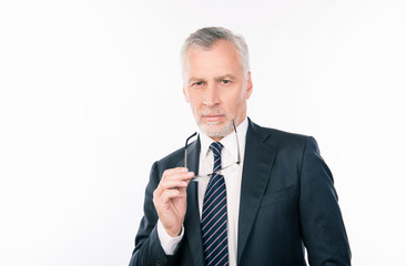 handsome intelligent  old businessman holding glasses and ponder