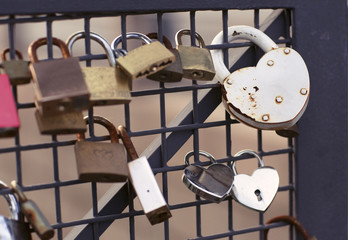 The rusty locks hang on the fence. Castle on a bridge of love.  