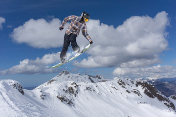 Naklejka na ściany i meble flying snowboarder on mountains