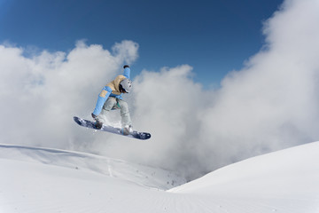 Naklejka na ściany i meble flying snowboarder on mountains
