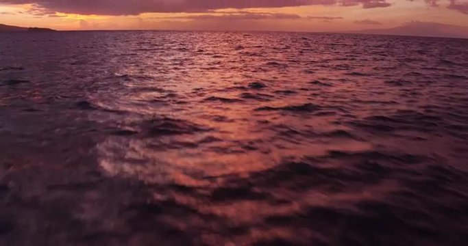 Sailing into the Sunset. Aerial View Flying Over Sail Boat. Shot in 4K. Amazing Vibrant Sunset in Hawaii