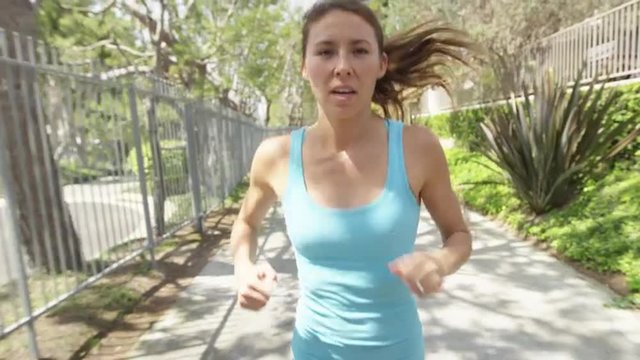 Fit young woman running towards camera