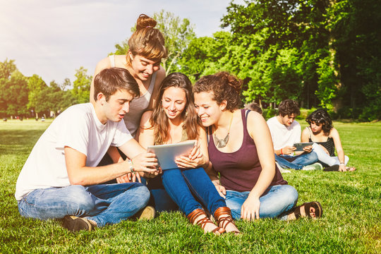 Group of Teenagers with Tablet PC at the Park
