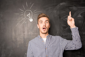 Young  man against the background of chalkboard having an idea