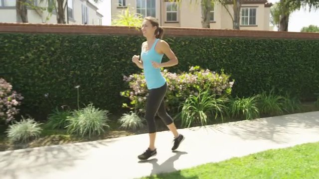 Healthy woman running on sidewalk