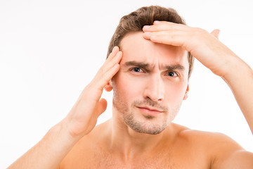 Handsome disturbed young man touching his face