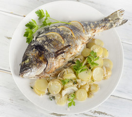 Fried fish with potatoes and parsley.