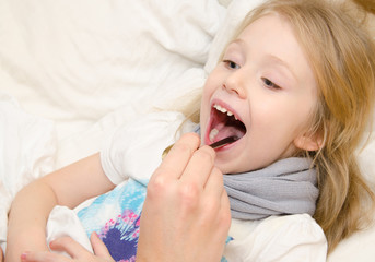 Pediatrician examining little girl's throat