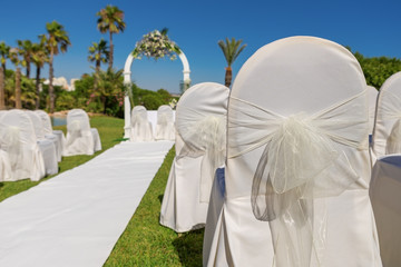 Detail of bow chair decoration for the wedding ceremony in garden. Close-up.