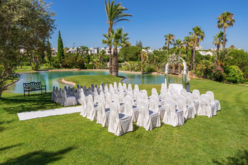 Decorations for the wedding ceremony in the garden. With white chairs.
