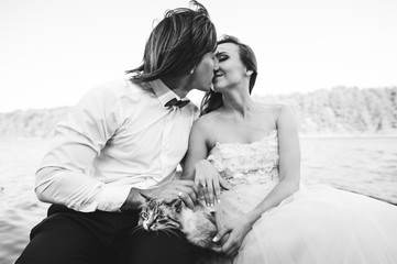 beautiful young wedding couple on a boat with a cat