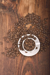 Roasted brown coffee beans & mug on wooden table