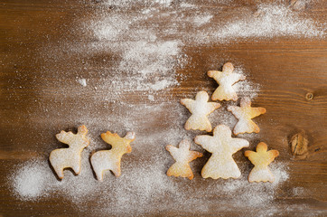 Christmas tree of homemade angel cookies on wooden background.