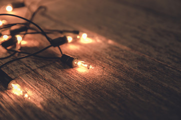 christmas light decor on wood background , color filter vintage tone