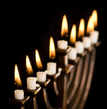 Beautiful lit hanukkah menorah on black.