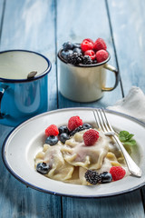 Homemade dumplings with berry fruits and cream